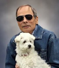 Man in sunglasses holding a white dog