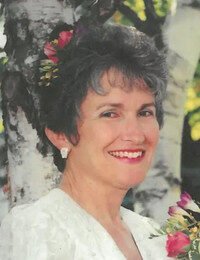 Smiling woman with flowers in hair near trees