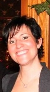 Smiling person in blue sequin dress indoors.