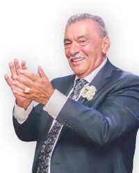 Smiling man in a suit clapping his hands.